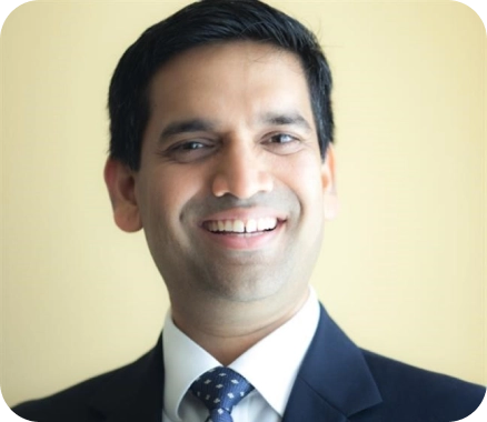 A smiling man wearing a suit and tie
